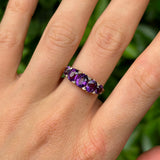 Antique, Victorian five-stone amethyst ring worn on hand.