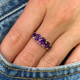 Antique, Victorian five-stone amethyst ring worn on hand.