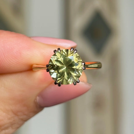 Vintage, 1980s single-stone chrysoberyl ring held in fingers.