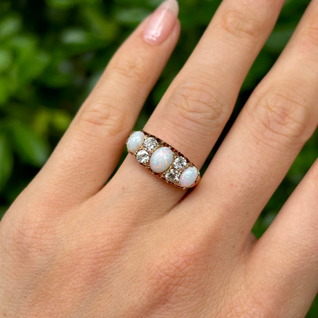 Victorian, opal & diamond three-stone ring worn on hand.