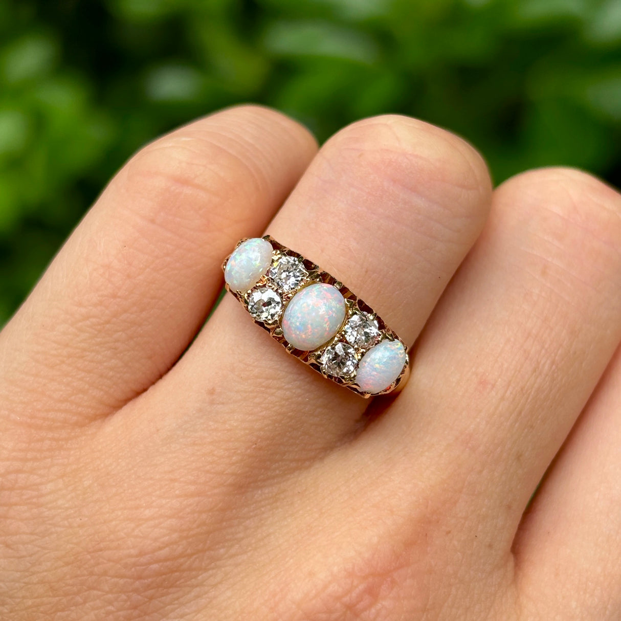 Victorian, opal & diamond three-stone ring worn on hand.