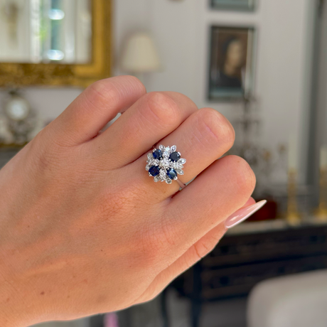 Sapphire and diamond cluster ring from 80s, worn on closed hand, front view. 