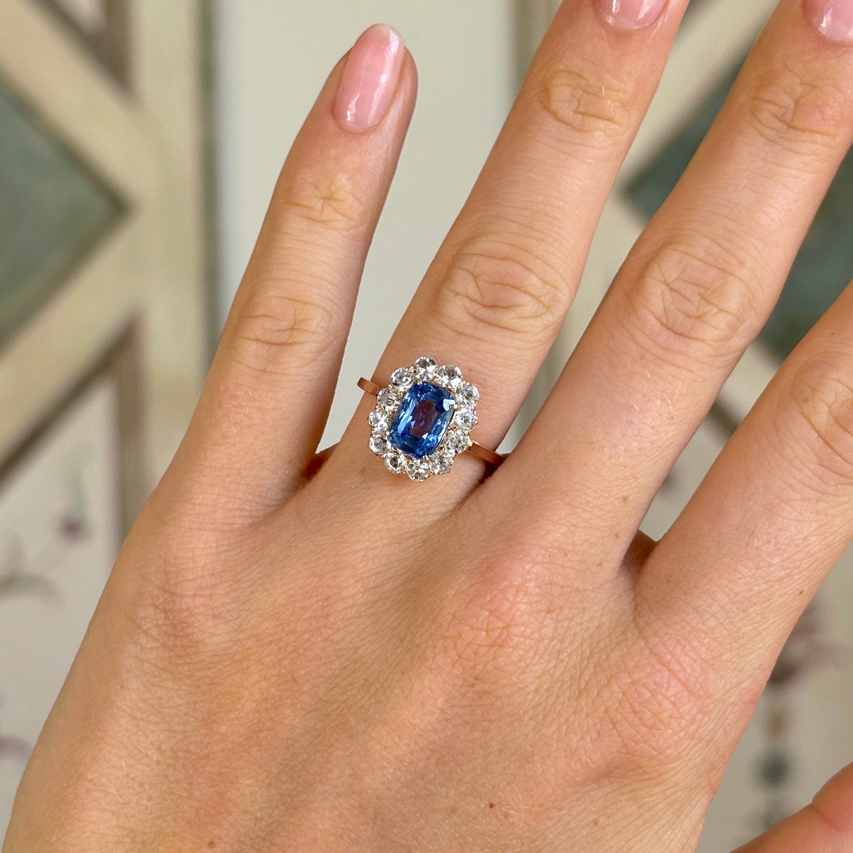 Antique, Edwardian blue & white sapphire cluster ring worn on hand.