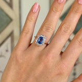 Antique, Edwardian blue & white sapphire cluster ring worn on hand.