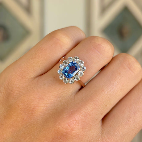 Antique, Edwardian blue & white sapphire cluster ring worn on hand.