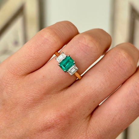 Vintage Emerald & diamond three-stone ring worn on hand.