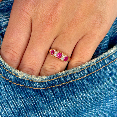 Antique, Victorian pinky-red ruby & diamond half-hoop ring worn on hand.