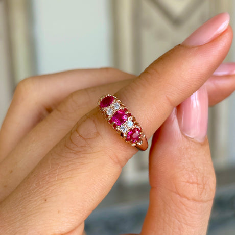 Antique, Victorian pinky-red ruby & diamond half-hoop ring worn on hand.