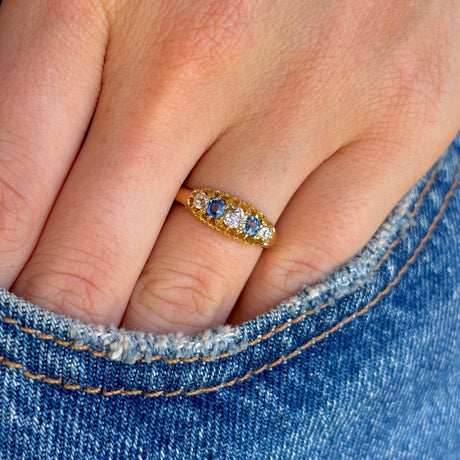 Antique, Edwardian sapphire & diamond five-stone ring worn on hand.