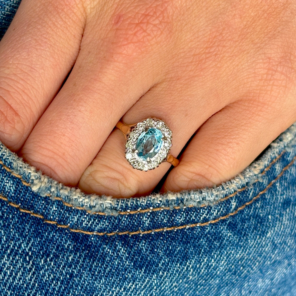 Antique, Edwardian blue topaz & diamond cluster ring worn on hand.