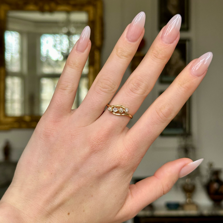 Antique four-stone diamond ring worn on hand.