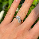 Antique, Edwardian diamond cluster ring worn on hand.