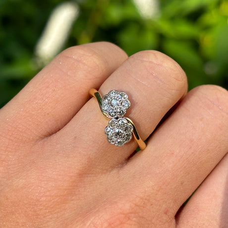 Antique, Edwardian diamond cluster ring worn on hand.