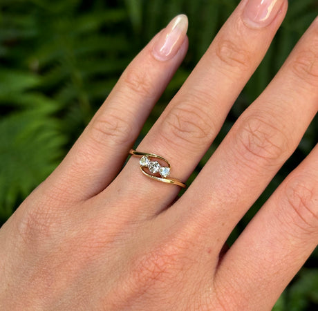 Antique, Edwardian three-stone diamond twist ring worn on hand.