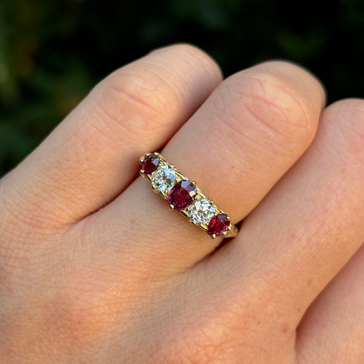 Antique, Victorian ruby & diamond five-stone ring worn on hand.