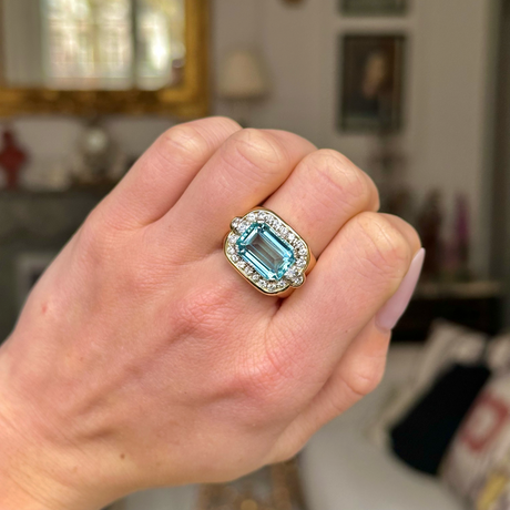 Aquamarine and diamond cocktail ring worn on closed hand. 