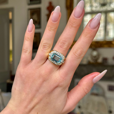 Aquamarine and diamond cocktail ring worn on hand. 