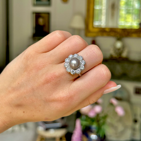 Antique natural pearl and diamond ring, worn on hand.