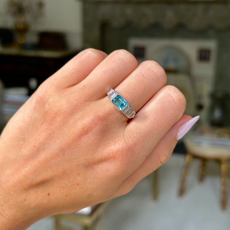 Vintage zircon and diamond ring, worn on closed hand,  front view. 