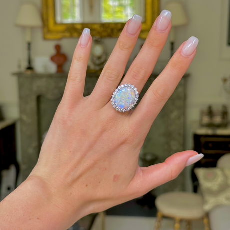 White opal and diamond cluster ring,  worn on hand.