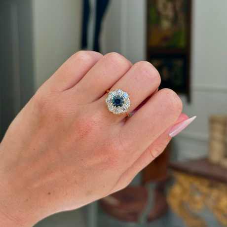 antique green sapphire and diamond cluster engagement ring, worn on closed hand, front view.