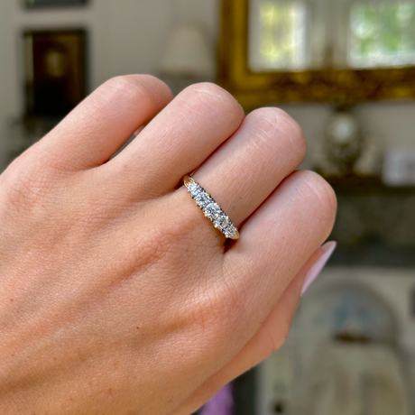 Edwardian diamond and 18ct yellow gold half hoop ring, worn on closed hand, front view. 