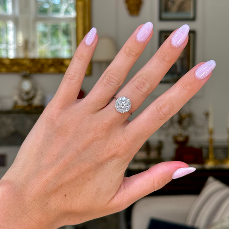 edwardian diamond daisy cluster engagement ring, worn on hand,  front view. 