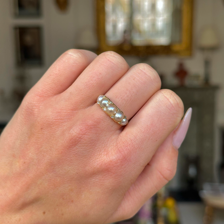 Georgian pearl half hoop ring worn on closed hand.