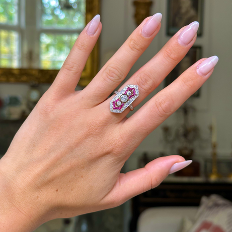 Antique ruby and diamond ring worn on hand. 