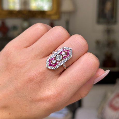 Antique ruby and diamond ring worn on closed hand. 