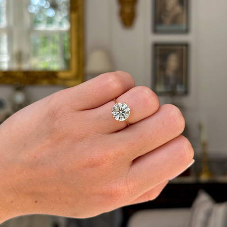 Vintage solitaire diamond engagement ring worn on closed hand. 