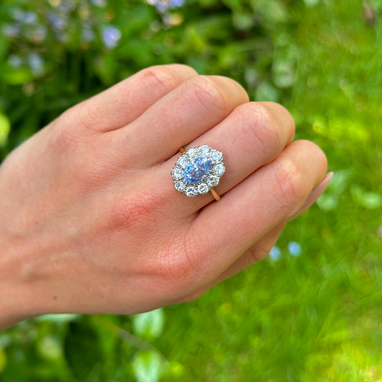 Vintage, 1980s cornflower blue sapphire & diamond cluster ring worn on hand.