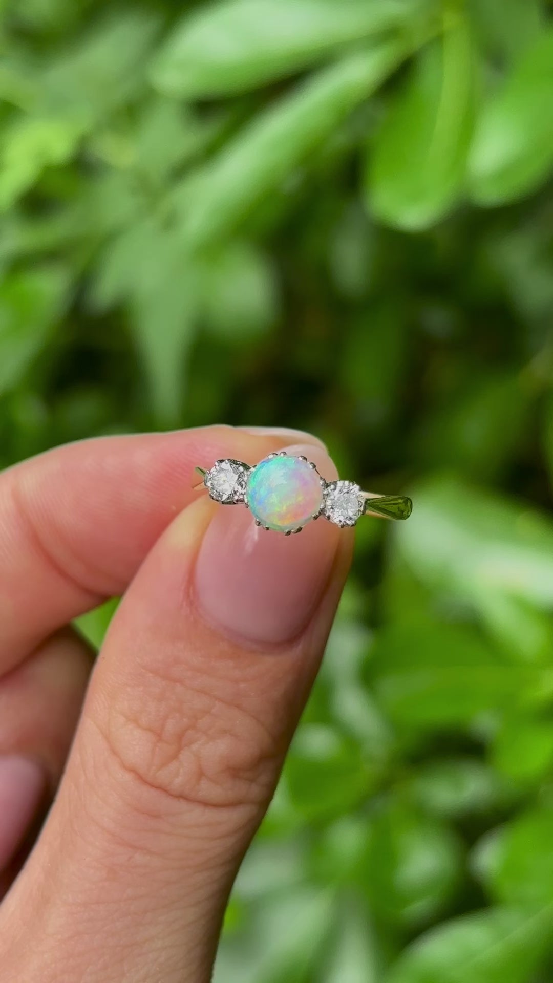 Antique, Edwardian opal and diamond three-stone ring in fingers in video.