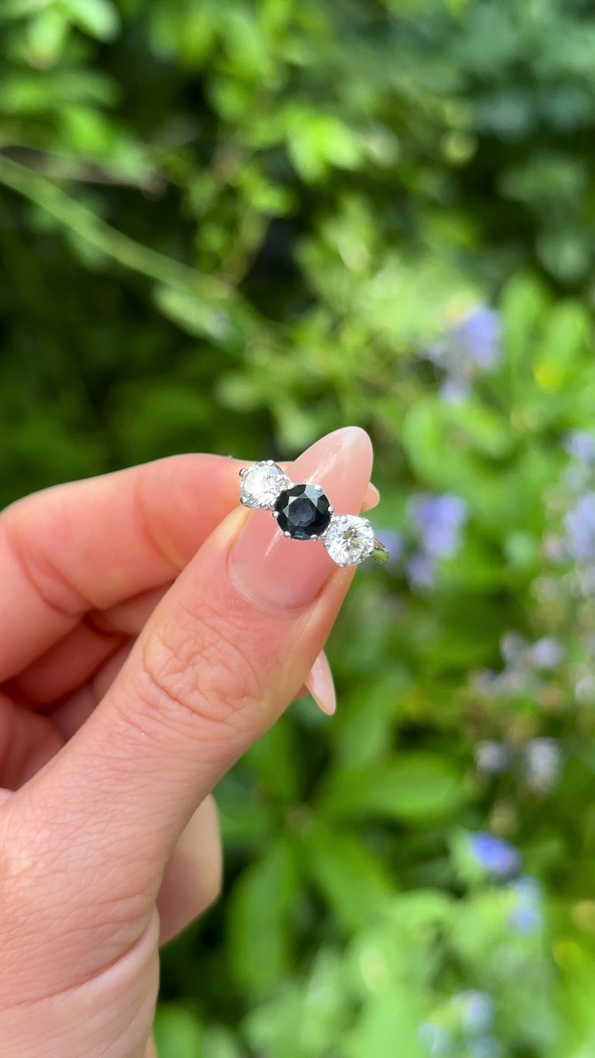 Vintage, 1980s Blue and White Sapphire Three-Stone Engagement Ring, 9ct White Gold held in fingers.