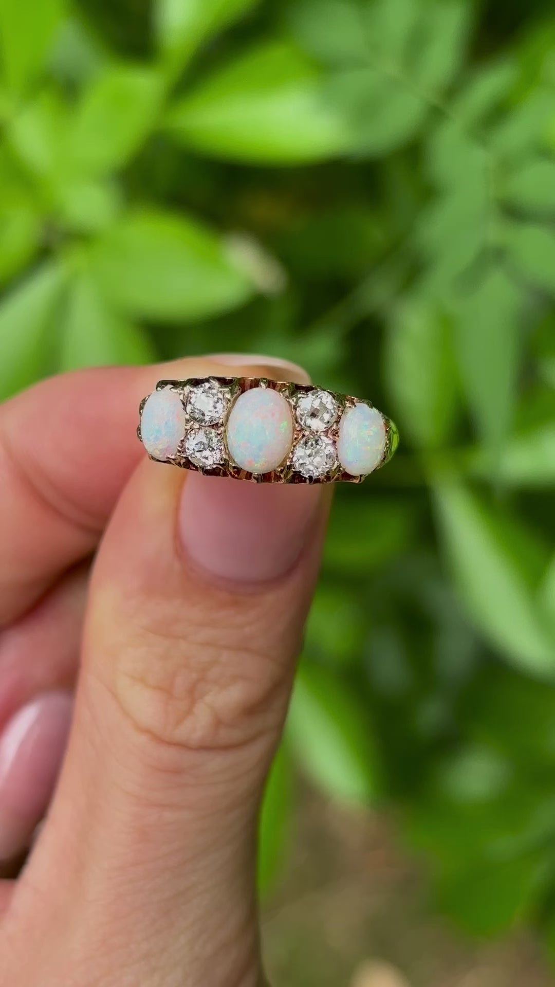 Victorian, opal & diamond three-stone ring held in fingers