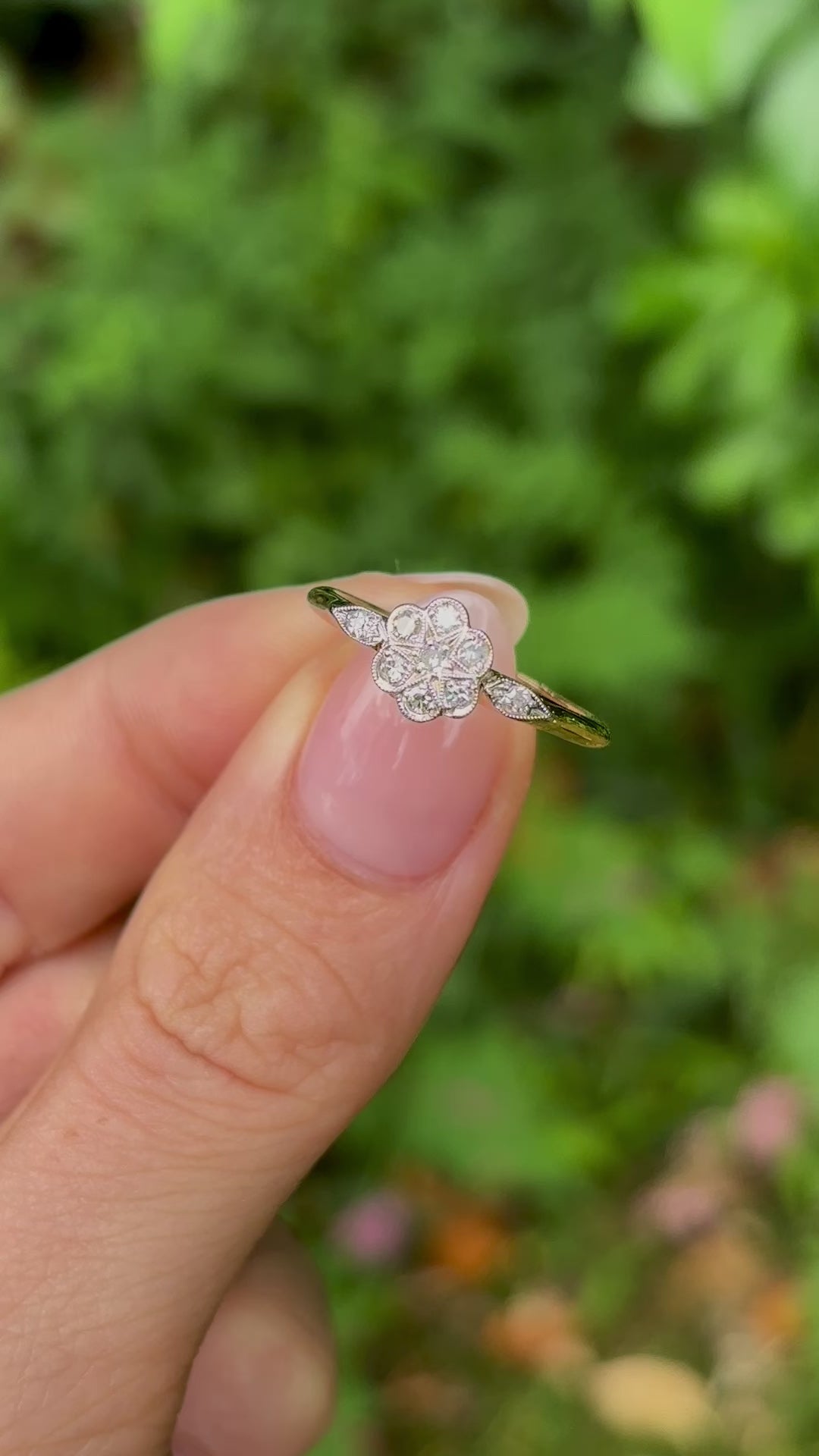 Antique, Edwardian diamond engagement ring held in fingers.