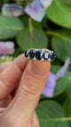 Antique, Victorian five stone sapphire ring held in fingers.