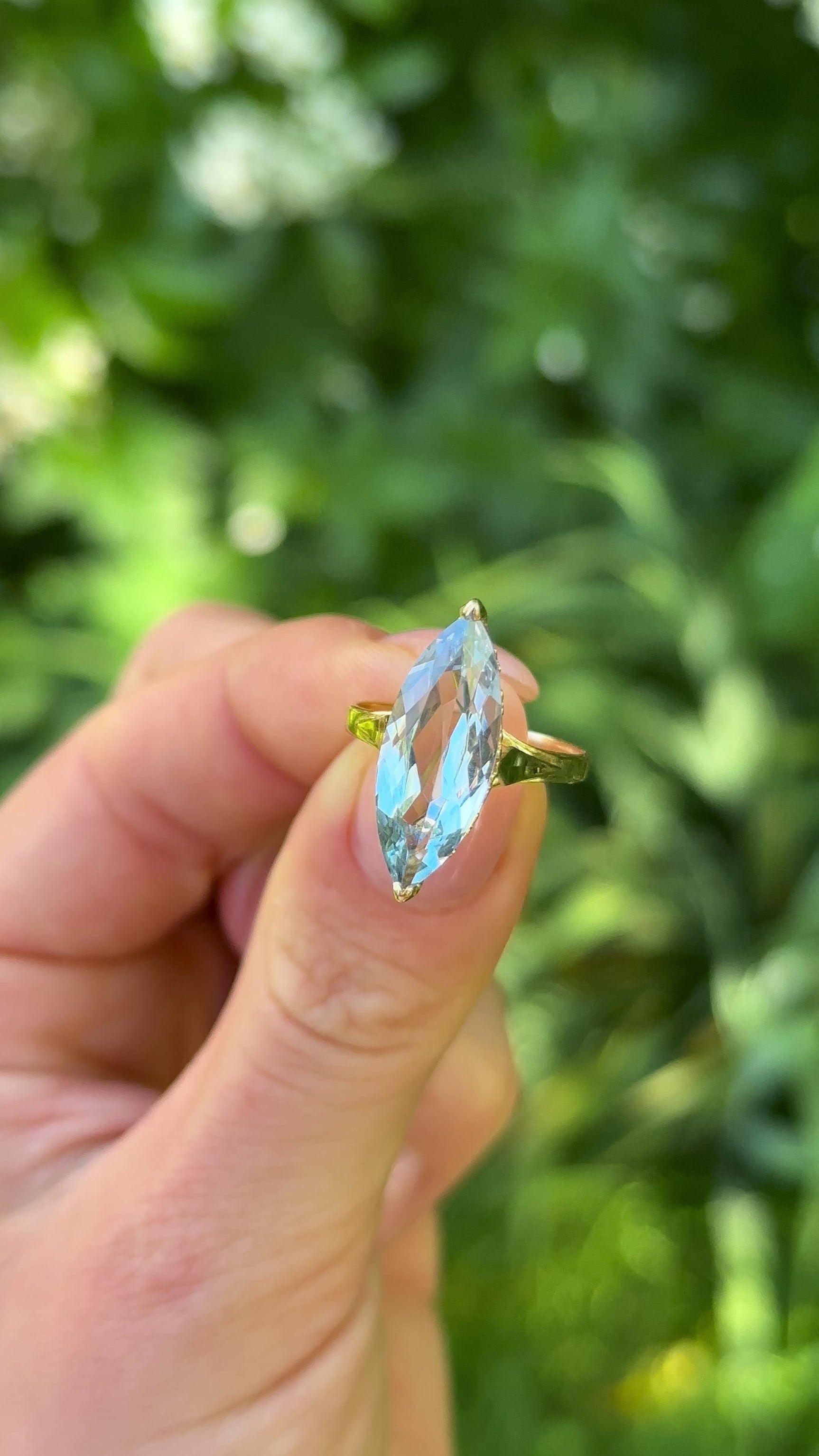 Antique Marquise-cut Aquamarine Ring, 18ct Yellow Gold held in fingers.