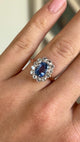 Antique, Edwardian blue & white sapphire cluster ring worn on hand.