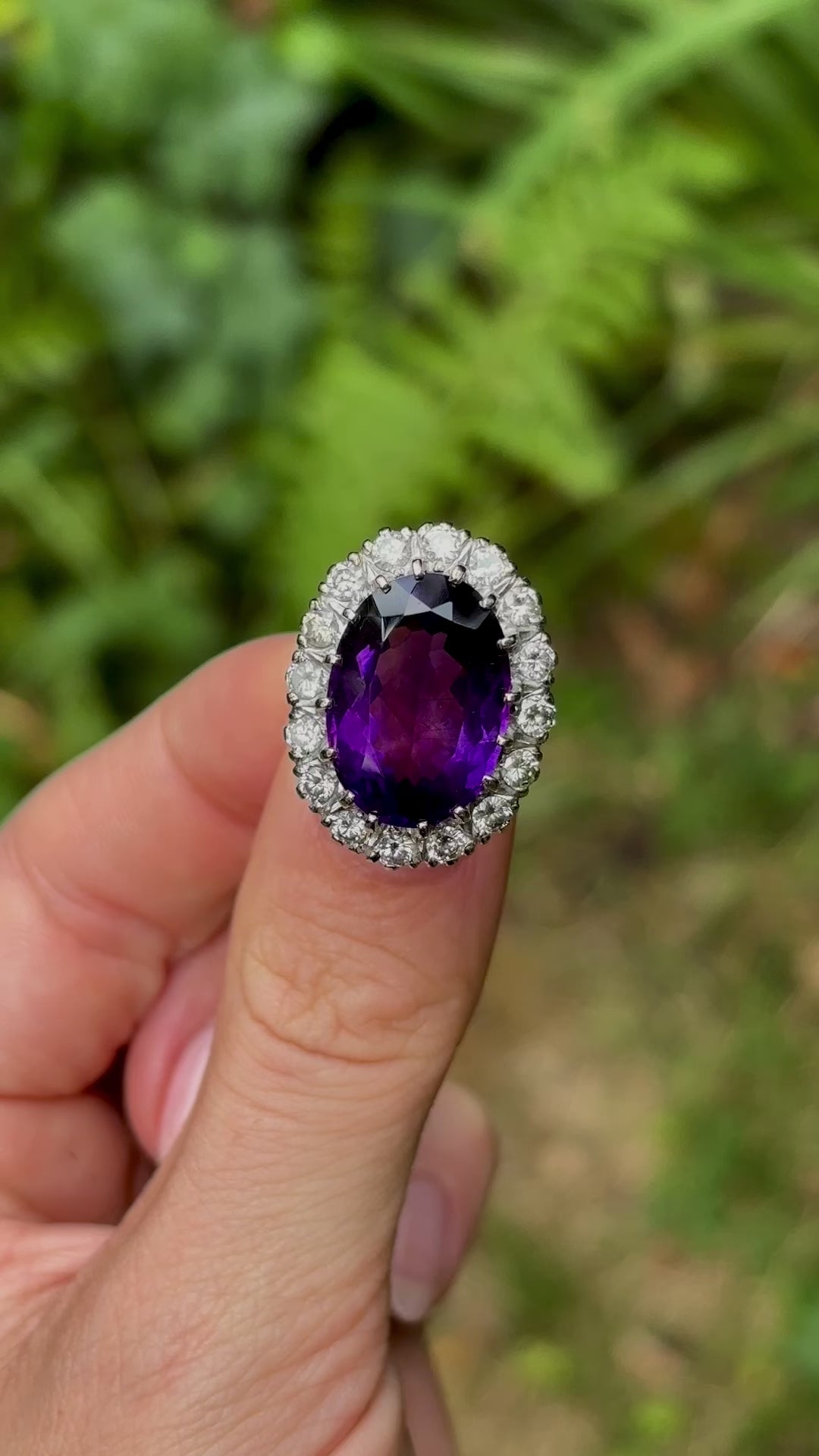 Antique, vintage amethyst & diamond cluster ring in fingers.