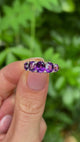 Antique, Victorian five-stone amethyst ring held in fingers.