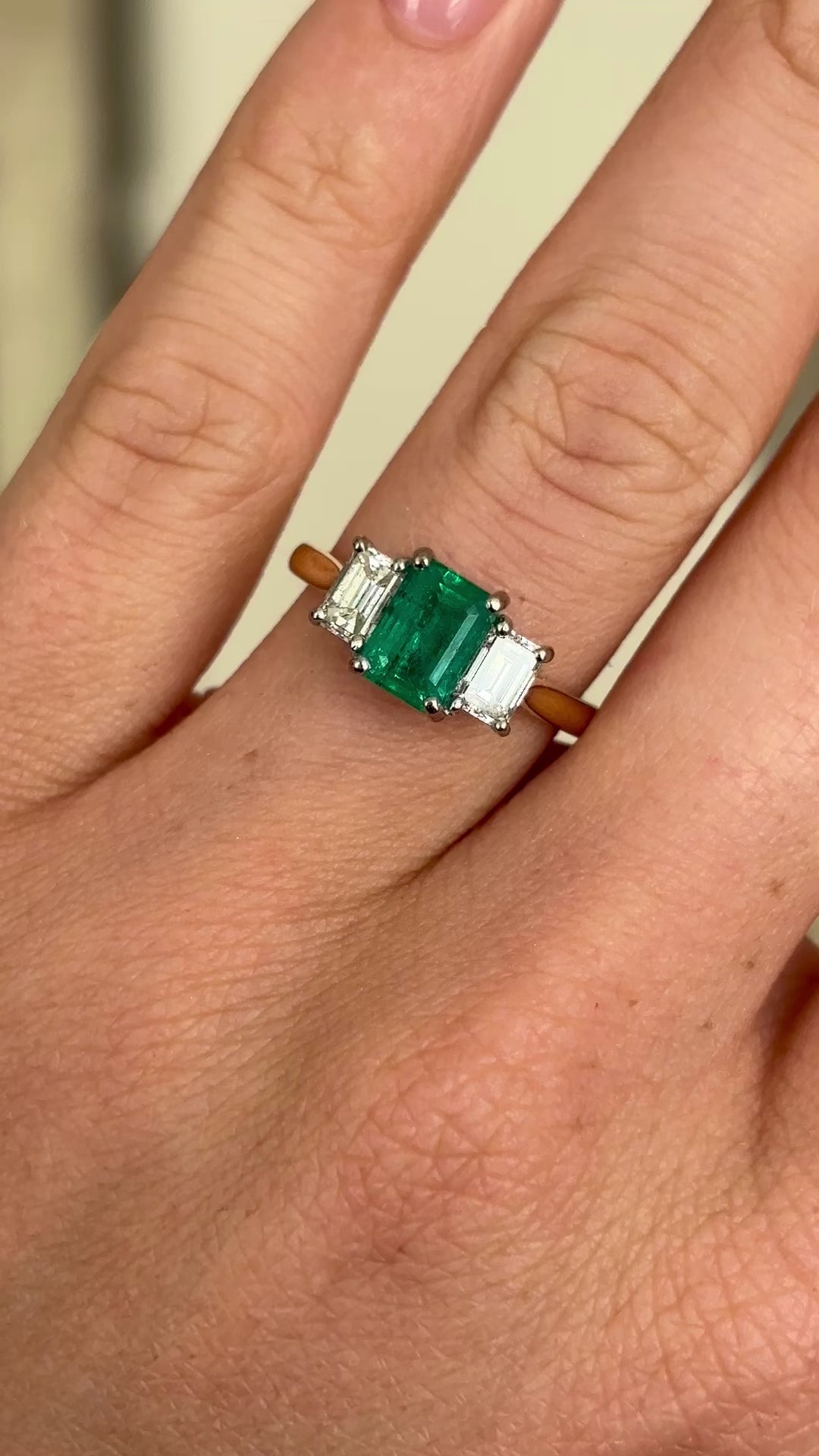 Vintage Emerald & diamond three-stone ring worn on hand.