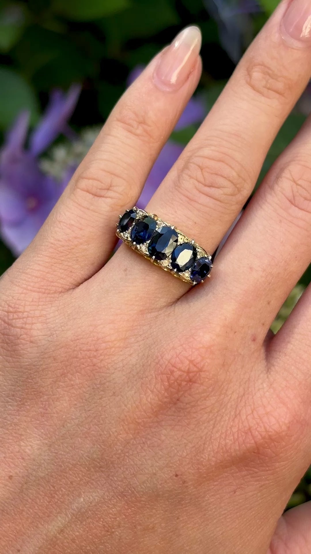 Antique, Victorian five stone sapphire ring worn on hand.