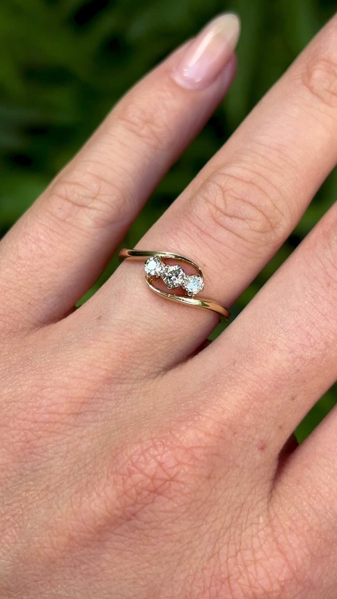 Antique, Edwardian three-stone diamond twist ring worn on hand.