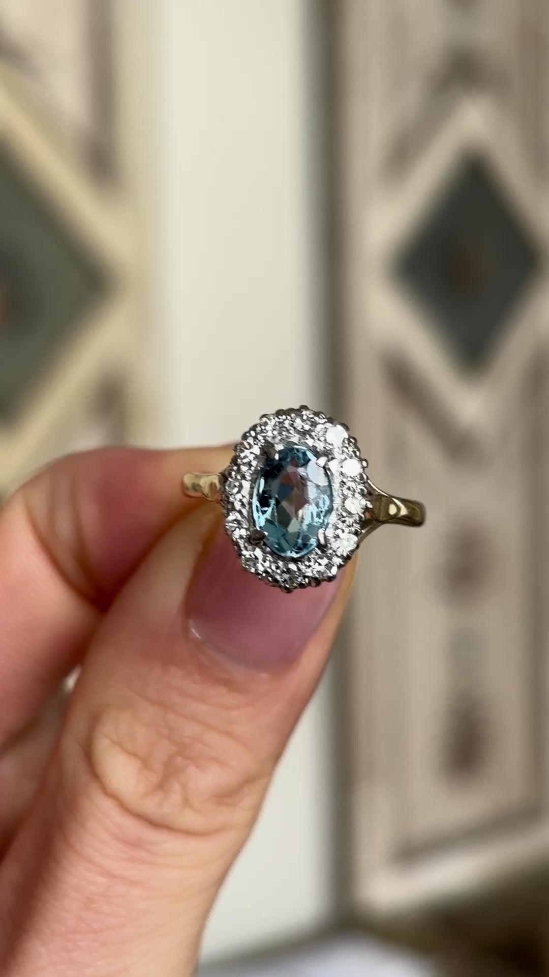 Antique, Edwardian blue topaz & diamond cluster ring held in fingers