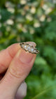 Antique, Edwardian five-stone diamond ring held in fingers