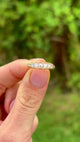 Antique, Edwardian five-stone diamond ring front held in fingers