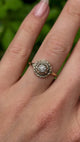 Vintage, solitaire diamond engagement ring worn on hand.