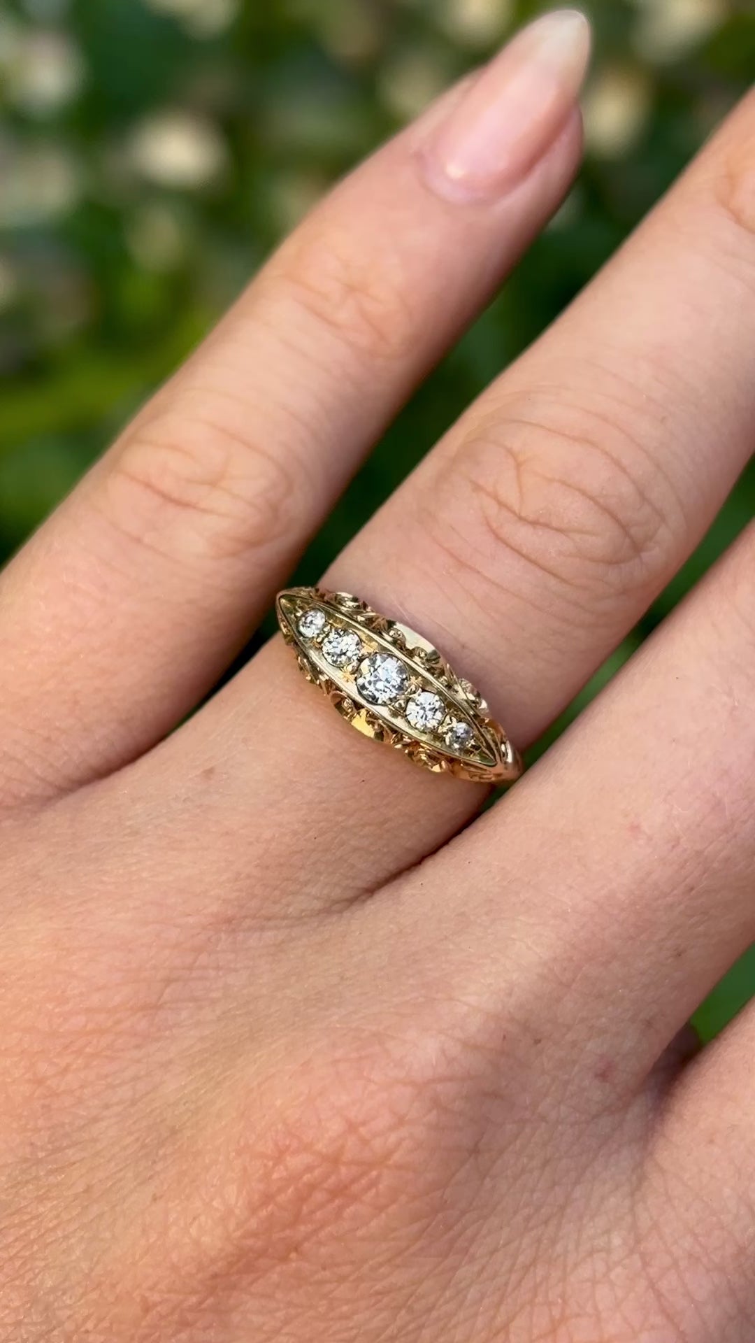 Antique, Edwardian five-stone diamond ring worn on hand and moved around