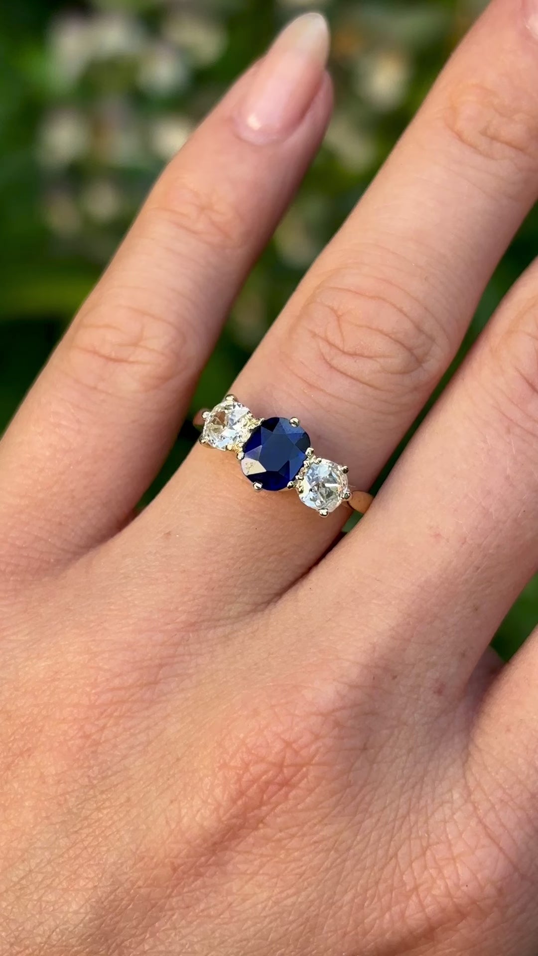 Vintage, 1980s sapphire and diamond three-stone ring worn on hand